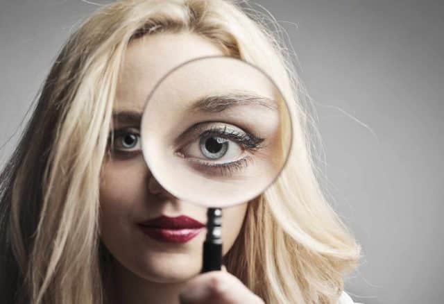 Woman looking through a magnifying glass